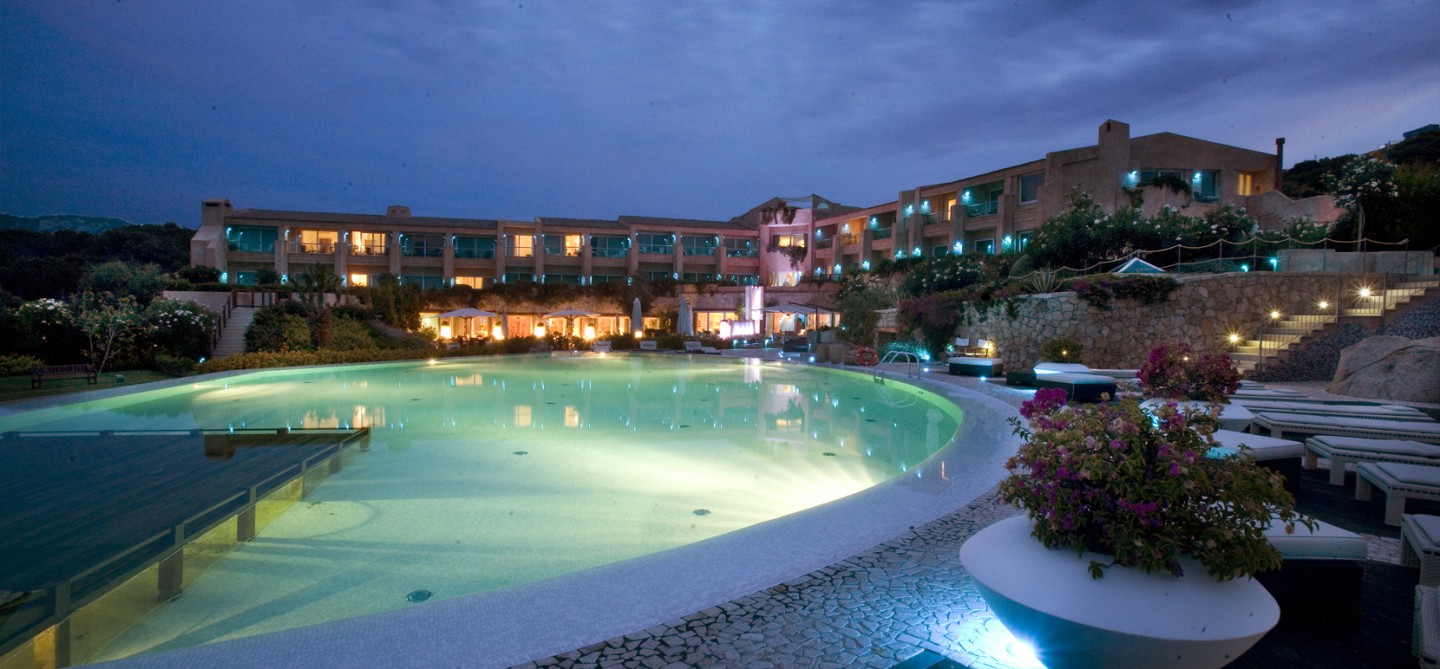 View of the swimming pool and resort in the evening at L Ea Bianca Luxury Resort in Sardinia