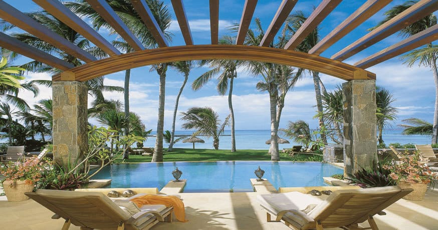 View of a private pool with two sun loungers and the Indian Ocean at One&Only Le Saint Geran in Mauritius